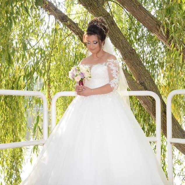 Rochie de mireasă tip prințesă cu dantelă aplicată manual pe m&acirc;neci și top și fustă amplă din tulle realizată la comandă de Lulytas Dresses