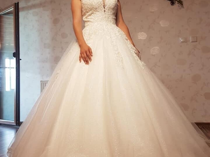 Rochie de mireasă tip prințesă cu plasă și mâneci pe umăr, decolteu adânc, îmbrăcată în dantelă aplicată manual și fustă amplă din tulle cu surje realizată la comandă de Lulytas Dresses